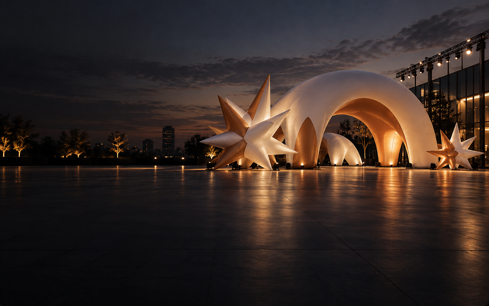 Concept visual of illuminated orange-and-white inflatable event structures at dusk.